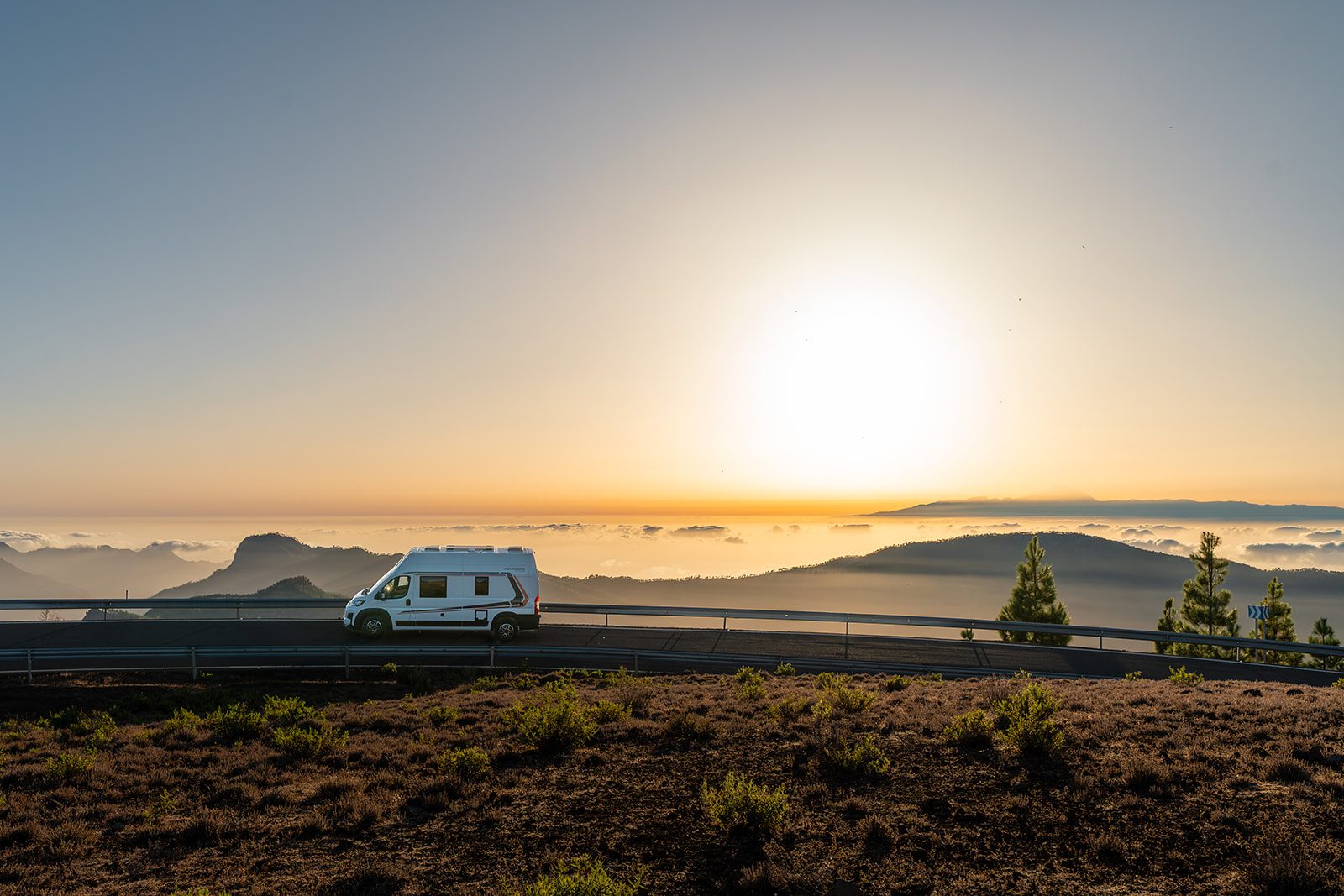 La camper al atardecer en la cumbre de Gran Canaria, con el sol cayendo sobre el mar de nubes